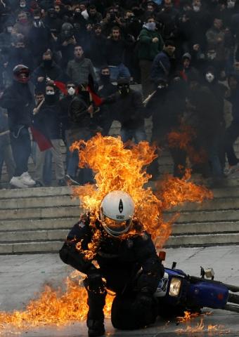 Grecia. miren como incendian este Policia con una botella de gasolina (Bomba Molotov)..!